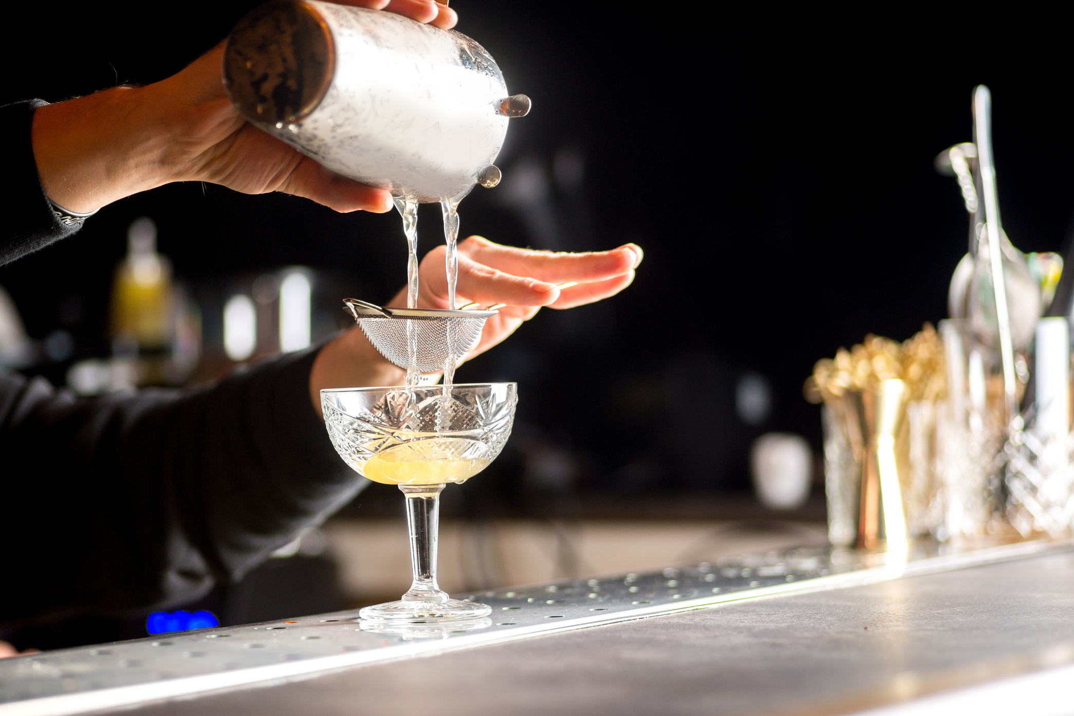 bartender is preparing a cocktail. Bartender pours a cocktail